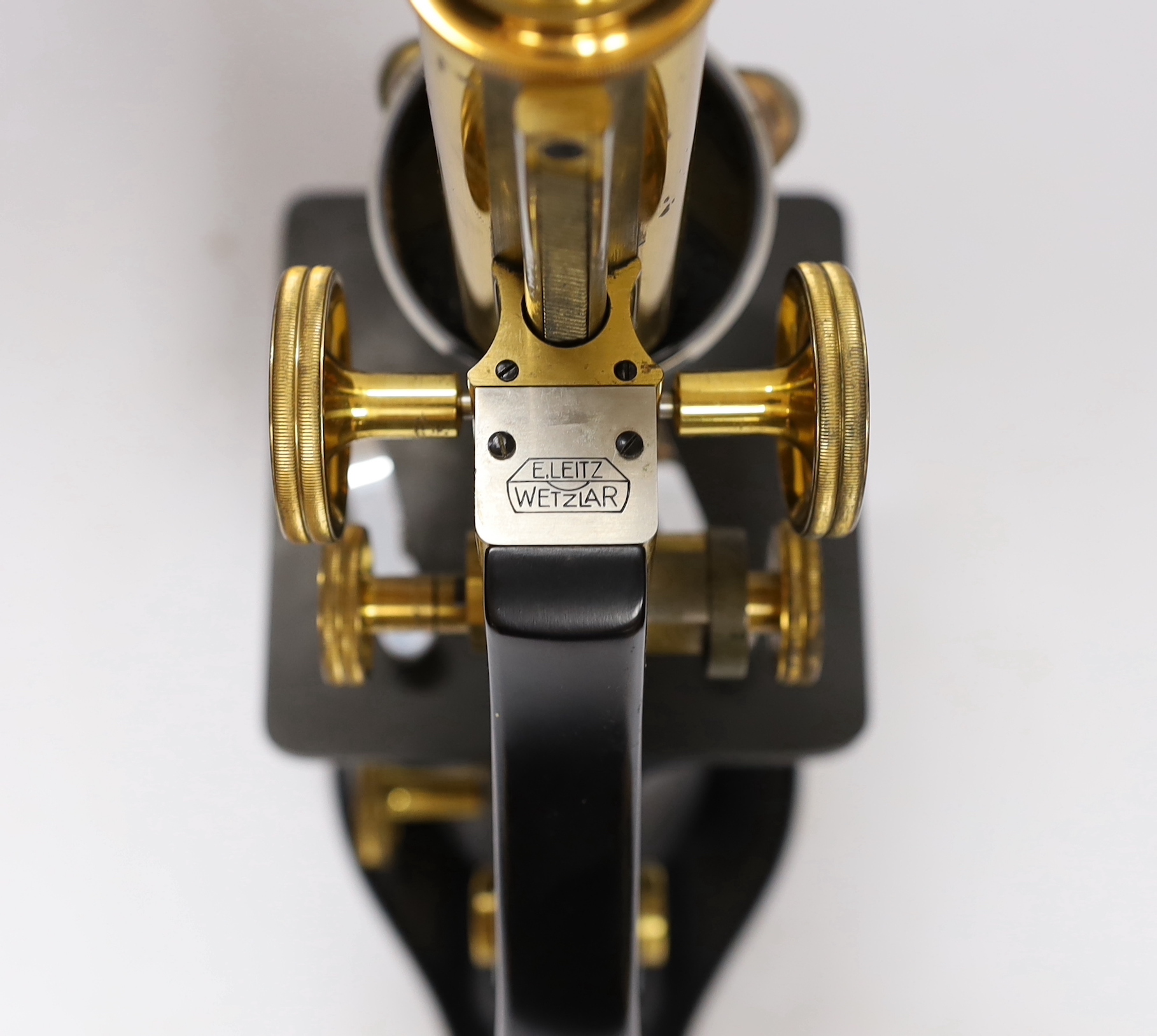 An early 20th century Leitz microscope in a teak case, with alternative lenses, card inserts and sliding compartment with glass slides, matching serial numbers stamped onto case and on magnification table